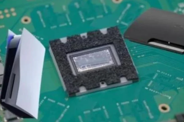 Vista de componentes electrónicos sobre una placa base, incluyendo un microprocesador con su encapsulado, una miniatura que evoca el diseño de la PS5 y un disco duro externo negro. La imagen simboliza el análisis de hardware necesario para proyectos como AnyPS5 que buscan compatibilidad de juegos de PlayStation 5 en PC.