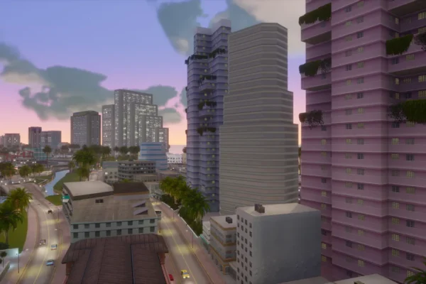 Vista aérea de una vibrante ciudad costera al atardecer, con rascacielos de estilo art déco, palmeras y una carretera con tráfico, evocando el ambiente de Vice City. Esta imagen ilustra el posible escenario de Grand Theft Auto VI, añadiendo contexto al rumor sobre su lanzamiento en PC.