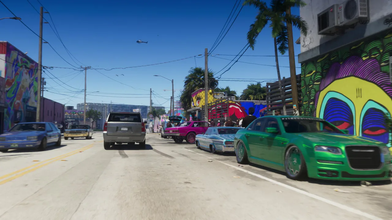 Escena diurna de Grand Theft Auto VI que muestra una calle de Vice City llena de coches personalizados y arte urbano colorido, capturando la atmósfera vibrante del juego.