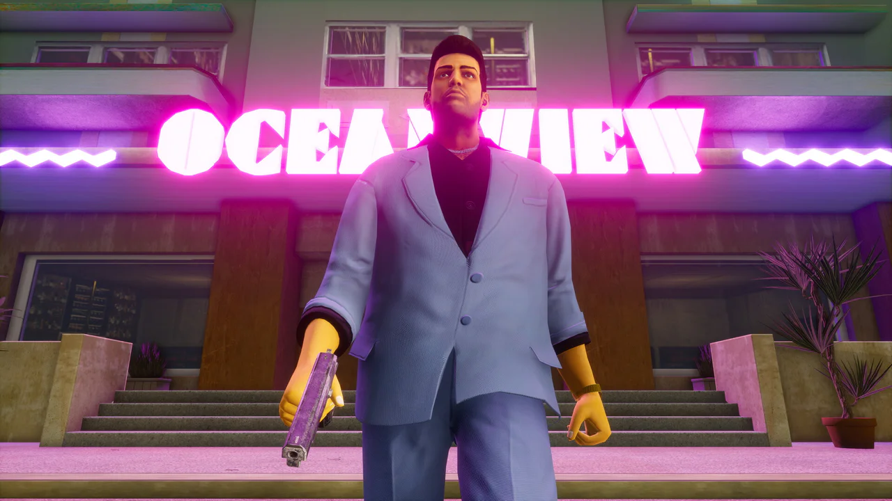 Un personaje masculino, vestido con un traje azul claro y guantes amarillos, sostiene una pistola mientras se erige frente a un edificio con un brillante letrero de neón rosa que dice 'OCEAN VIEW', evocando la estética de Grand Theft Auto VI.
